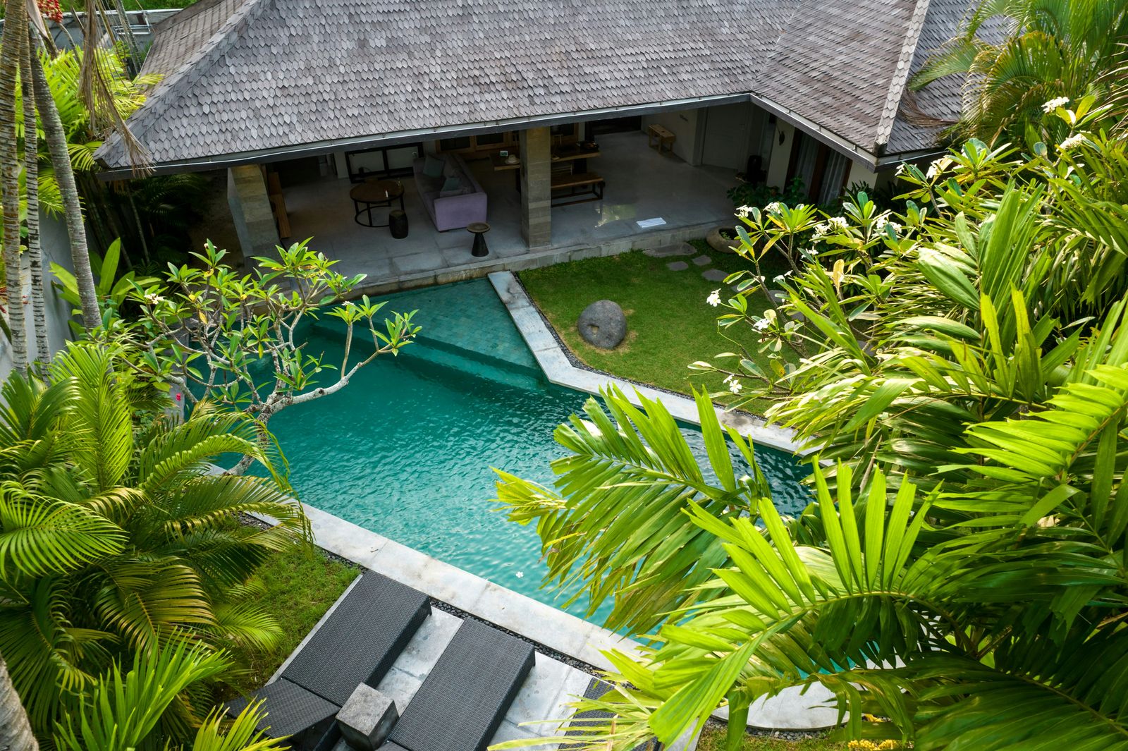 Luftaufnahme einer Bali-Villa mit Pool, umgeben von tropischer Vegetation